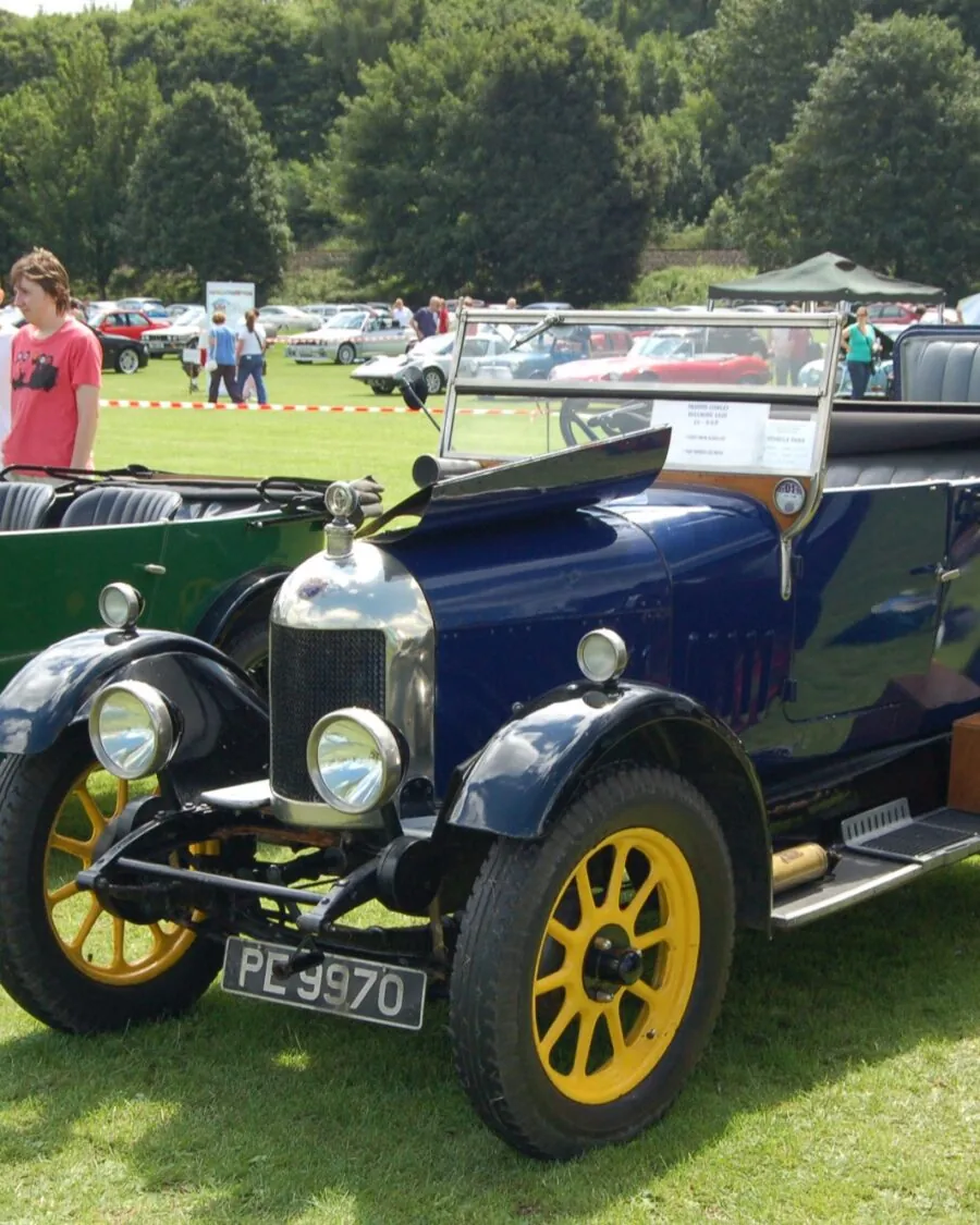 Тёмно-синий двухместный открытый автомобиль Morris Cowley 1926 года с жёлтыми колёсами на траве выставки